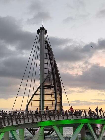 A bridge with a green walkway and people walking. 3