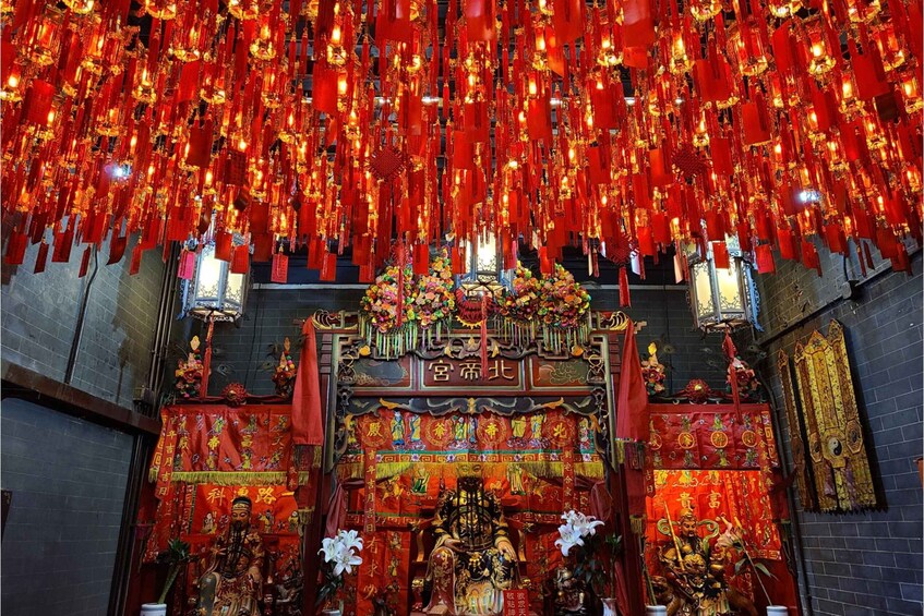 A temple interior with red lanterns, statues, and intricate decorations. 2