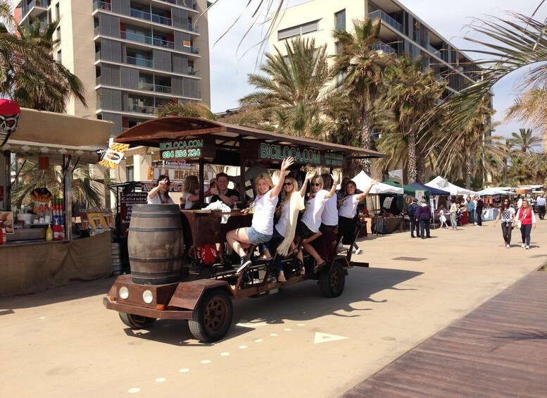 A group of people on a vintage trolley ride, with palm trees and a market in the background. 3