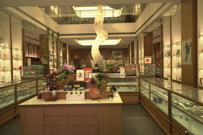 A modern interior with glass display cases, wooden counters, and decorative plants. 2