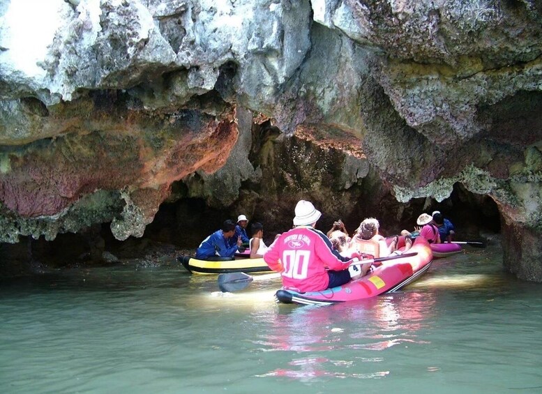 People in kayaks navigating through a cave. 5