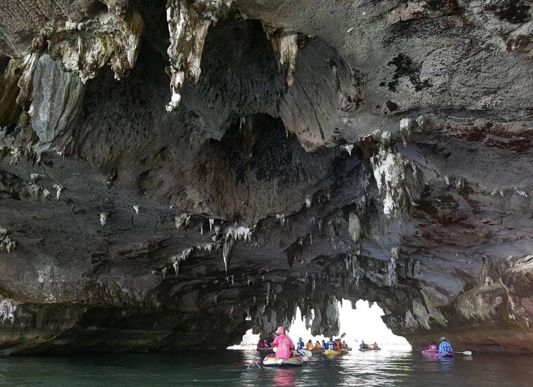 A group kayaking through a cave with stalactites. 4