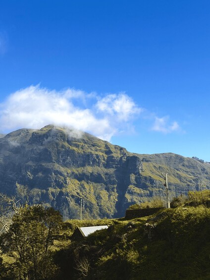 A mountain landscape with a small house and a power line. 5