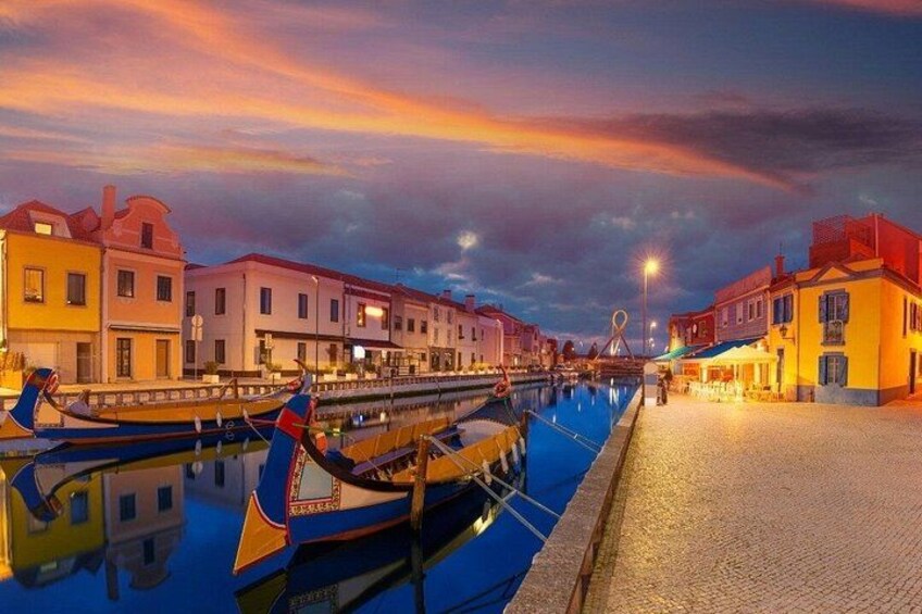 A canal with gondolas, waterfront buildings, and a sunset sky. 4