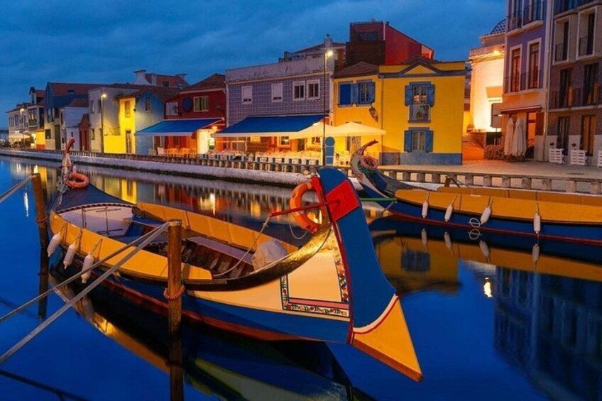 A waterfront with colorful buildings and boats docked at a marina. 2