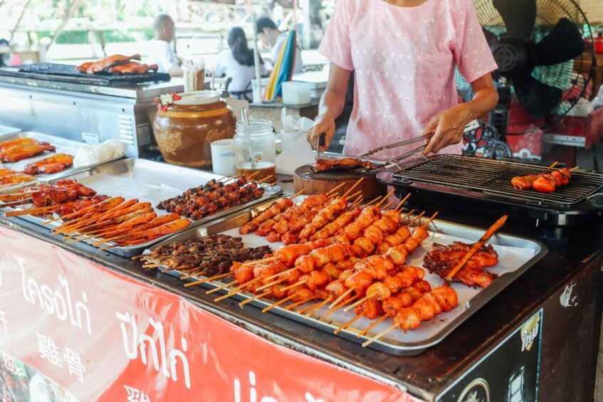 A food stall with various skewered meats and a large pot. 3