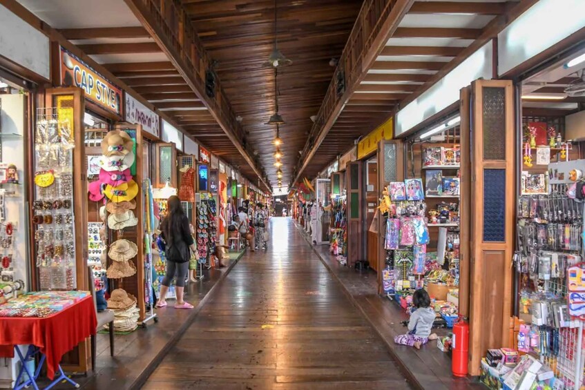 A wooden indoor market with various stalls selling hats, toys, and other items. 5