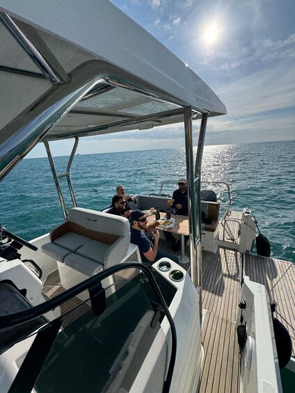 A boat with people dining on deck, surrounded by water. 4