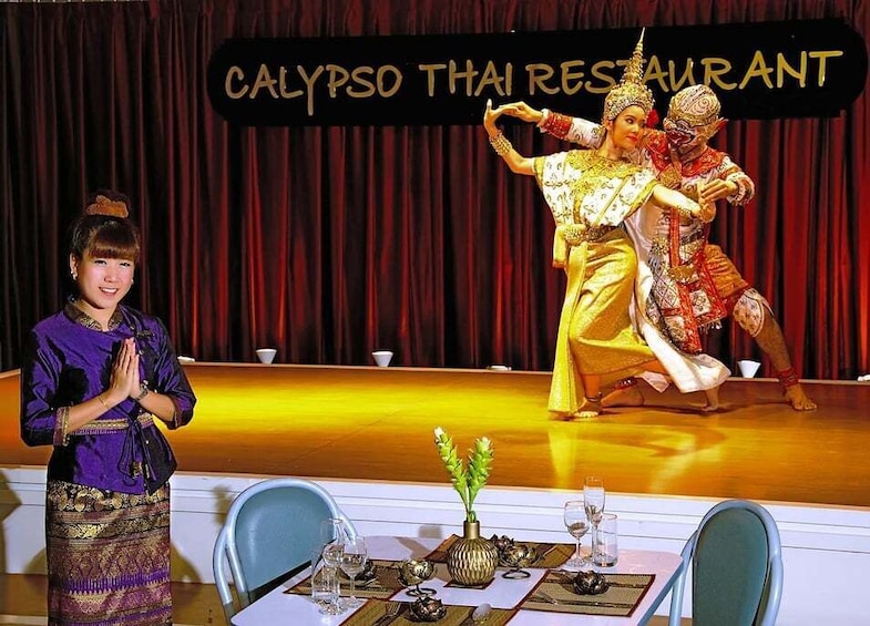 A stage with a sign reading 'CALYPSO THAI RESTAURANT' and a person in traditional Thai attire performing. 2