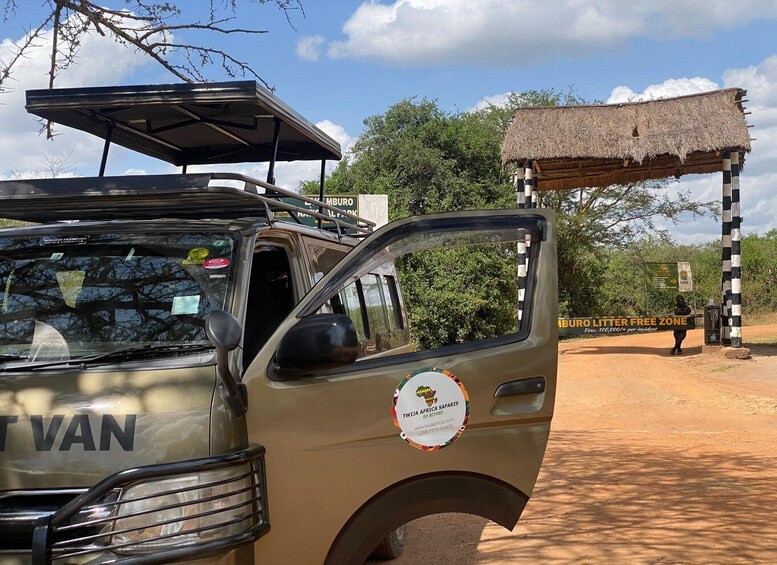 A safari vehicle with a 'TWIZA AFRICA SAFARIS' logo, parked near a 'LITTER FREE ZONE' sign. 4