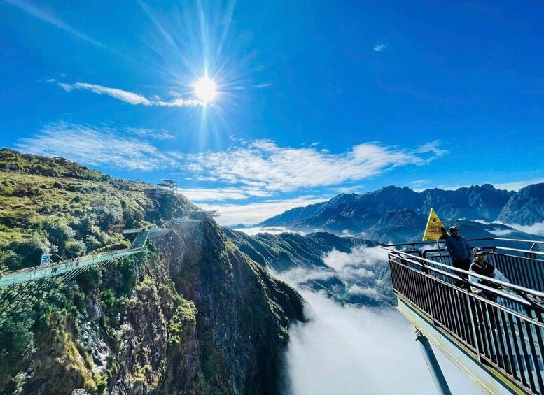 A mountain landscape with a bridge, a person holding a flag, and a clear sky. 2