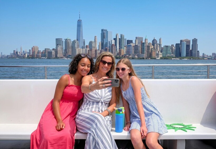 Three people on a boat with a city skyline in the background. 3