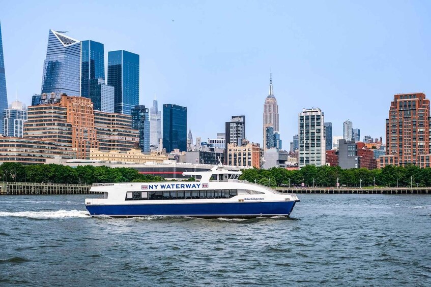 A boat named NY Waterway traveling on a river with a city skyline in the background. 2