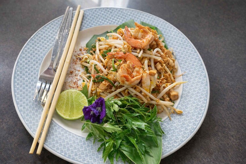 A plate of Pad Thai with shrimp, bean sprouts, and lime. 3