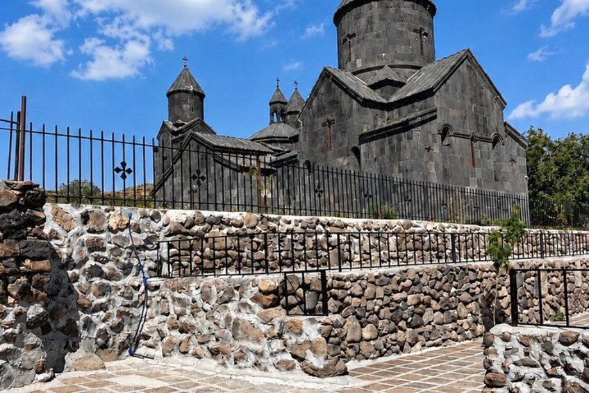 A stone church with a fence and a stone wall in front. 5