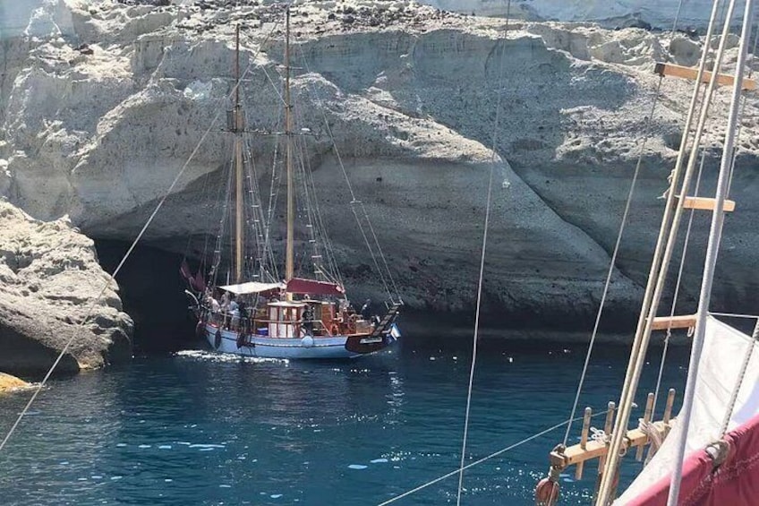 A sailing boat anchored near rocky cliffs. 4