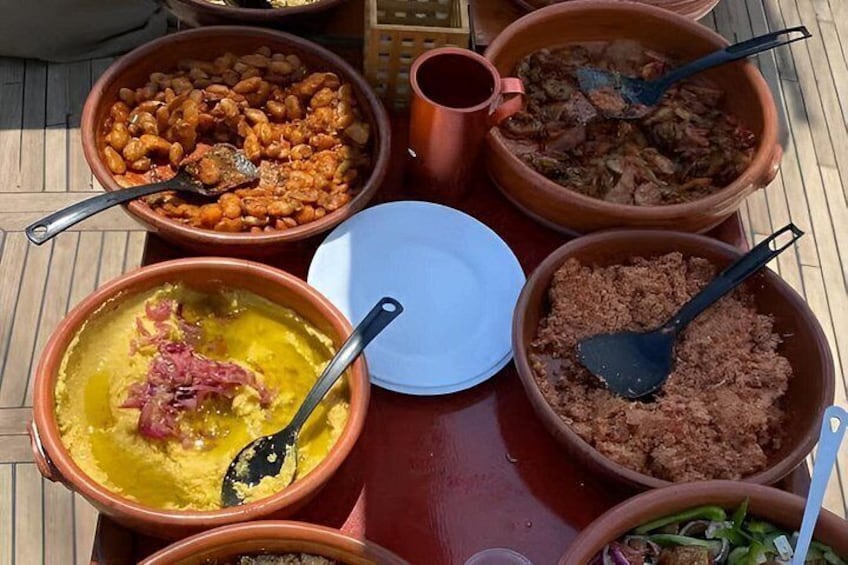A variety of dishes in clay pots on a wooden table. 3