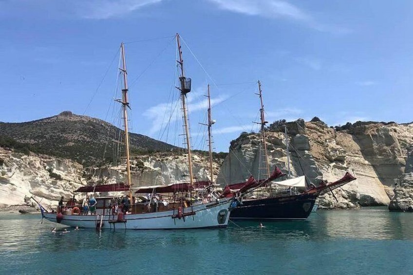 A sailing boat docked at a rocky coastline with a clear sky. 5