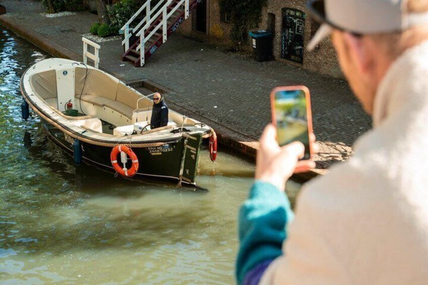 A small boat on a canal with a person taking a photo. 3