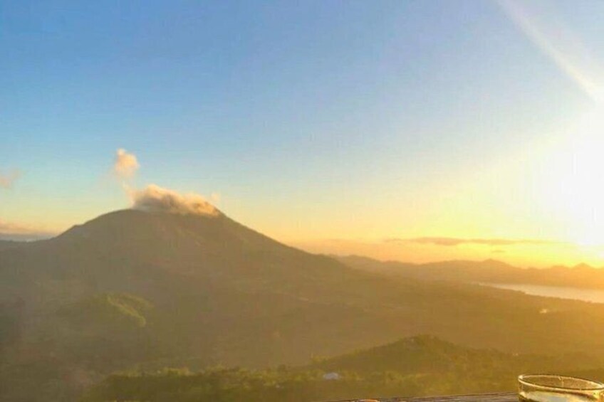 A mountain with a cloud at its peak and a sunset in the background. 2