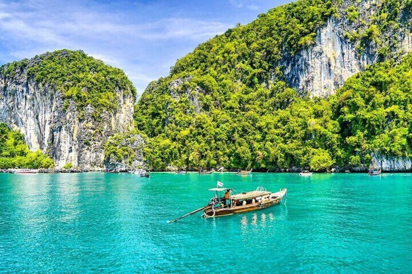 A boat on turquoise water with cliffs in the background. 1