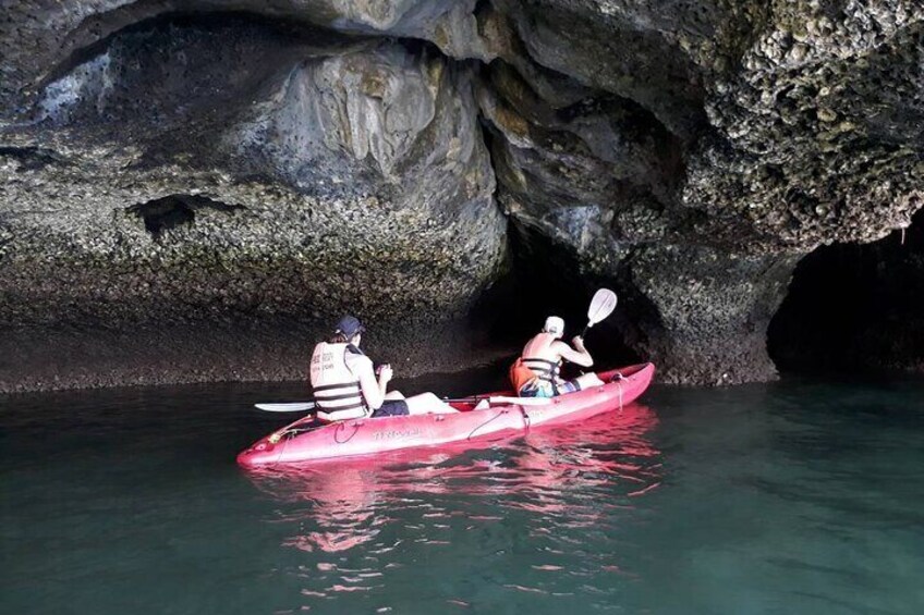 Two people kayaking in a cave with water. 3