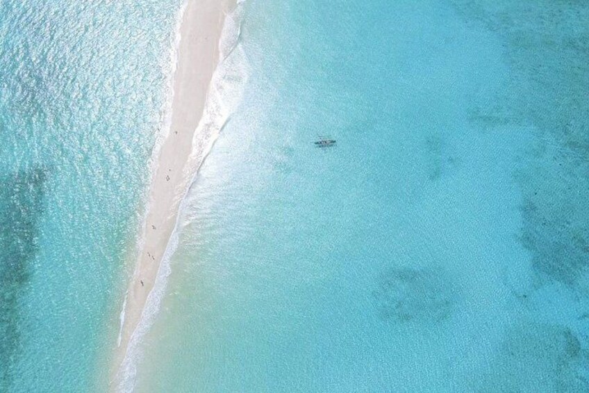 A beach with clear turquoise water and a sandy shore. 1
