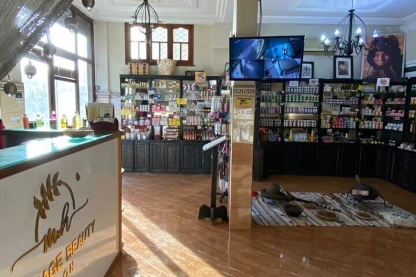 A salon interior with a reception desk, shelves of beauty products, and a television screen. 3