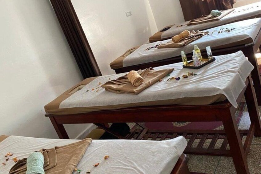 A room with massage tables, towels, and bottles, likely for a spa service. 2