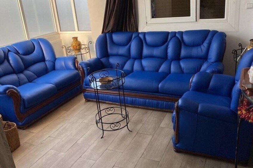A blue leather sofa set with a matching armchair and a small side table. 4