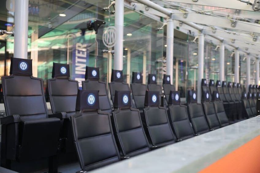 Rows of black seats with a logo, a glass wall, and a sign that reads 'INTER'. 4