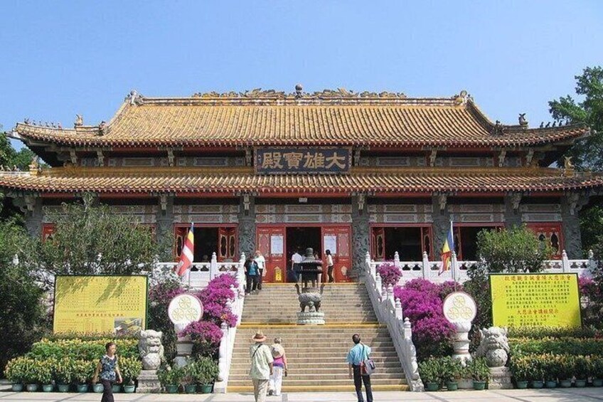 A traditional Chinese building with a tiled roof, a staircase leading to the entrance, and a signboard in front. 4