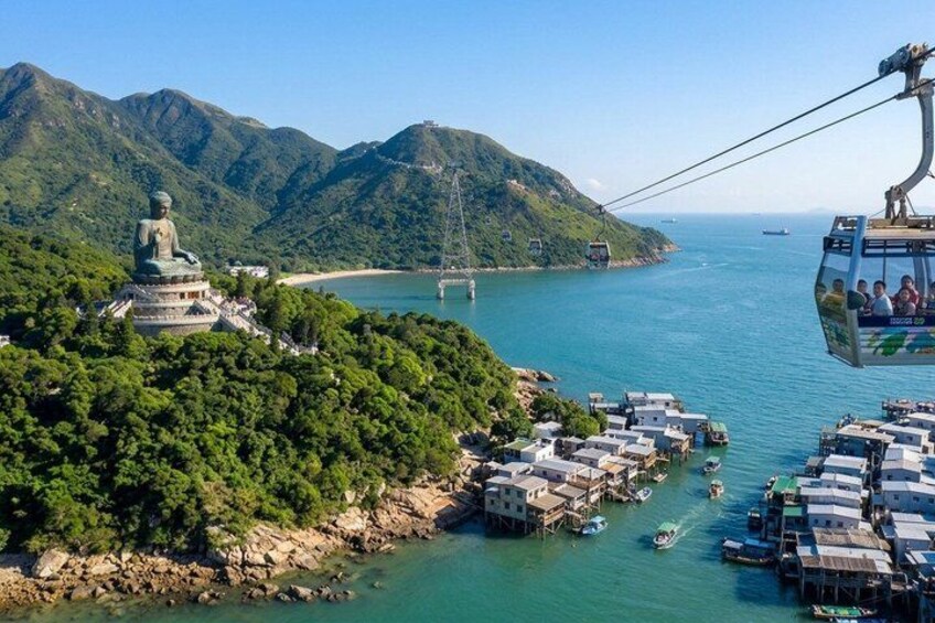 A large Buddha statue, a cable car, and a coastal village with boats. 1