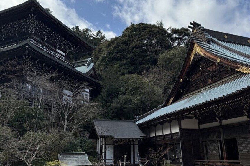 Traditional Japanese architecture with wooden buildings and a mountainous backdrop. 4