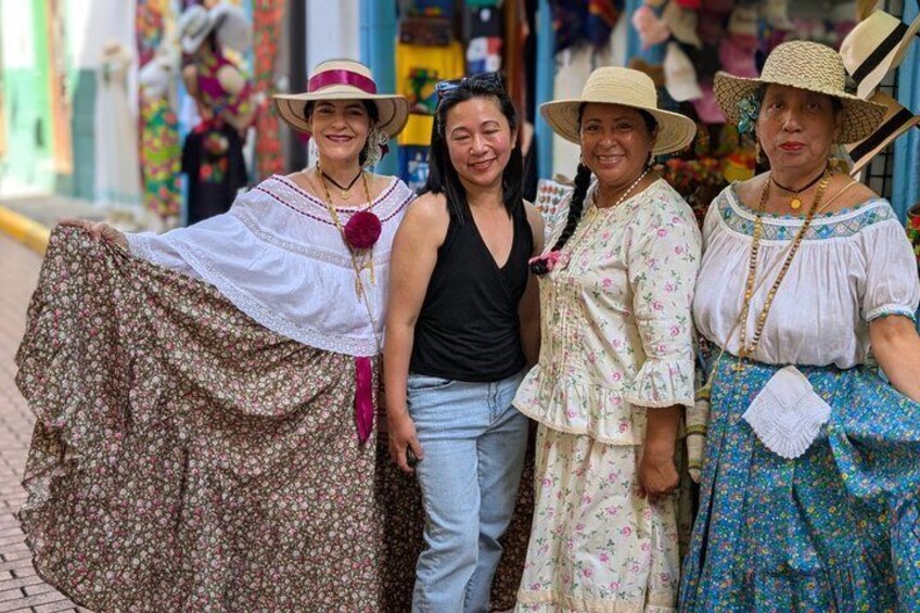 Four people in traditional attire standing on a street. 3