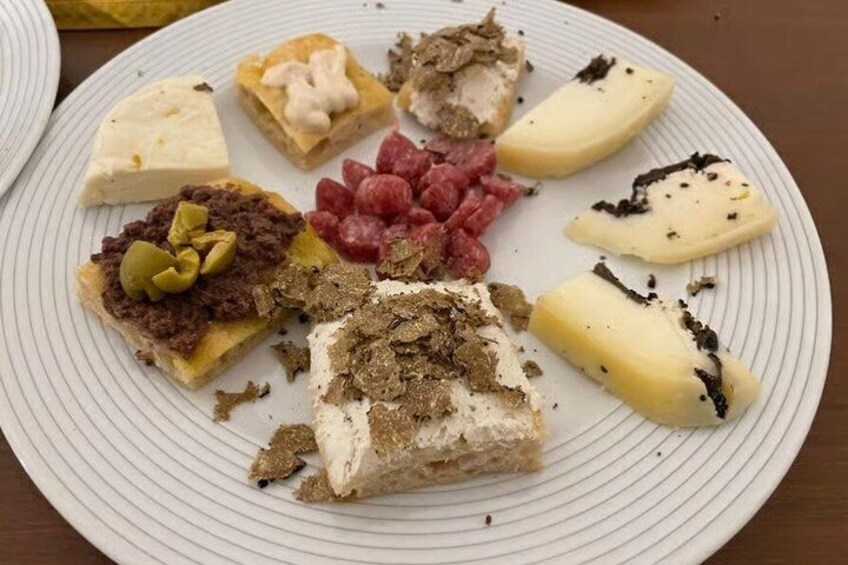 A plate with various food items including cheese, meat, and possibly some nuts. 4
