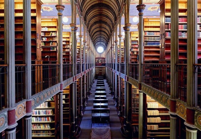 A grand library with rows of bookshelves and ornate columns. 2