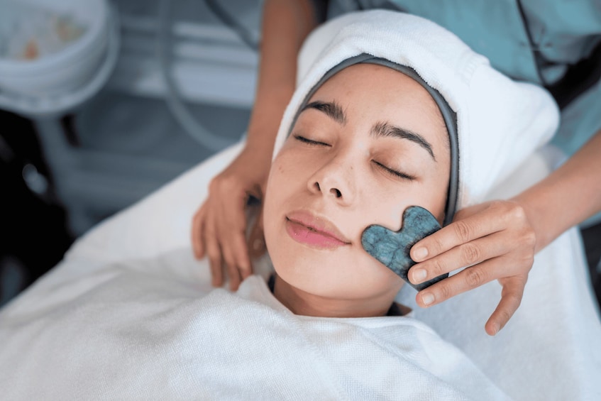 A person receiving a facial treatment with a blue sponge. 3