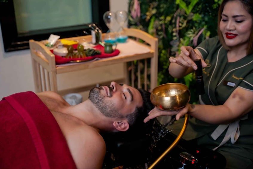 A person receiving a massage with a bowl and oil bottle. 1