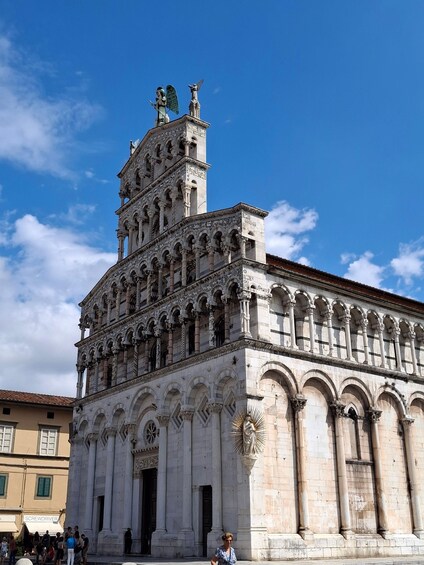 A historic building with intricate architectural details, including a tower with statues and a large entrance. 1