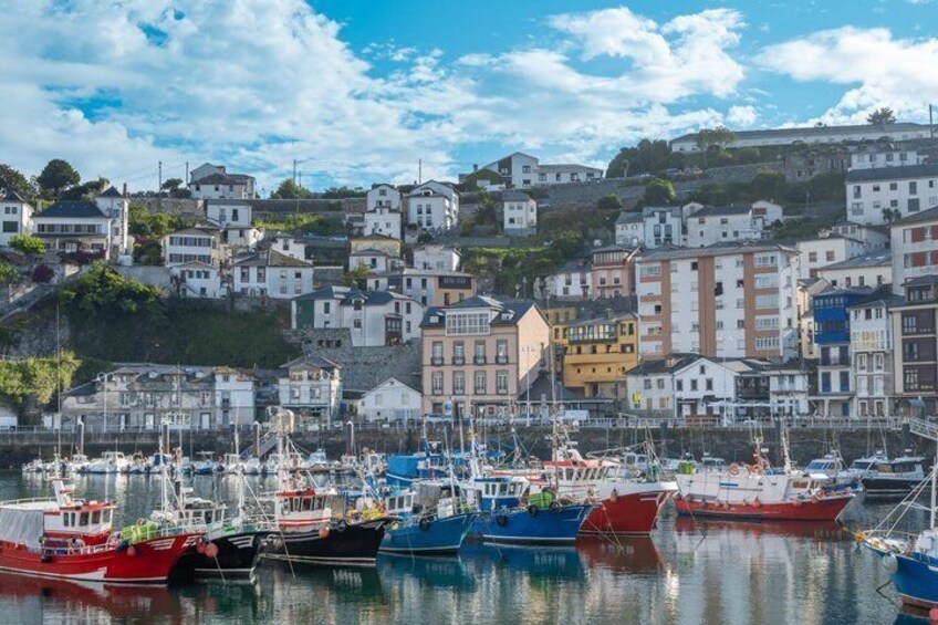 A harbor with boats, buildings, and a hillside. 4