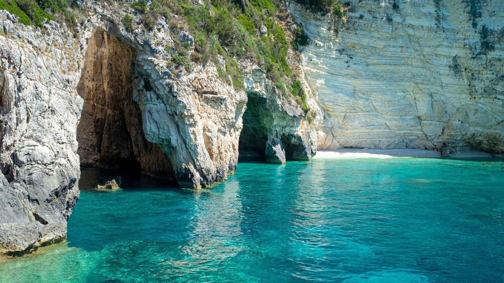 A coastal cave entrance with clear turquoise water. 2