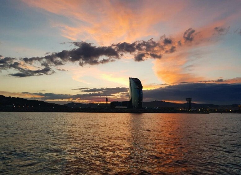 A sunset over a body of water with a modern building reflecting the sky. 4
