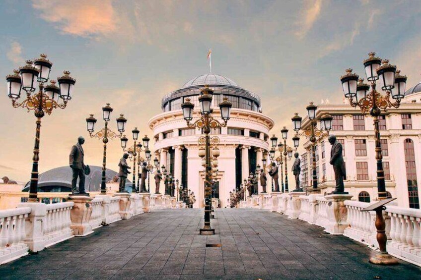 A grand building with a dome, surrounded by statues and ornate street lamps. 4
