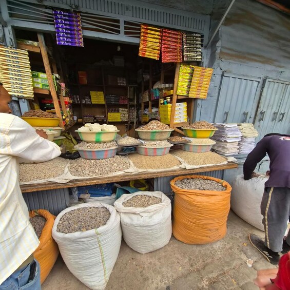 A market stall with various grains and legumes displayed in bowls and sacks. 2