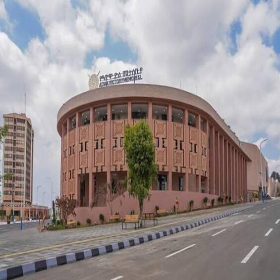 A building with a curved facade and a sign that reads 'Victory Memorial.' 5