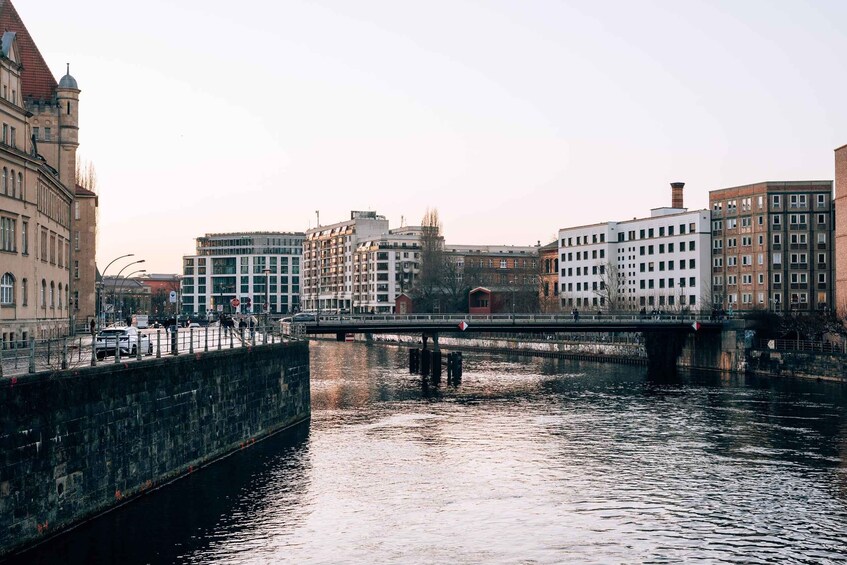 A river with a bridge, buildings, and a stone wall. 5