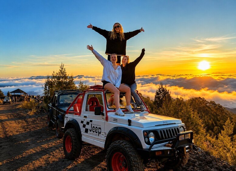 Two people on a Jeep with a sunrise in the background. 3