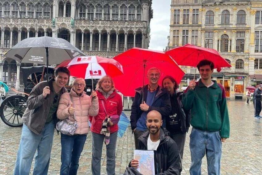 A group of people standing in a cobblestone square with historic buildings in the background. 2