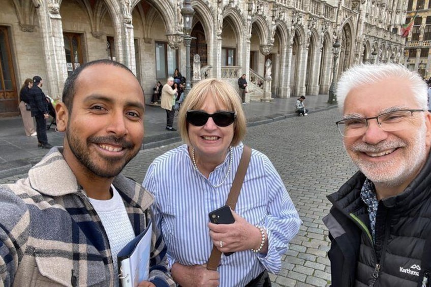 Three people standing in front of a historic building with arches and columns. 4